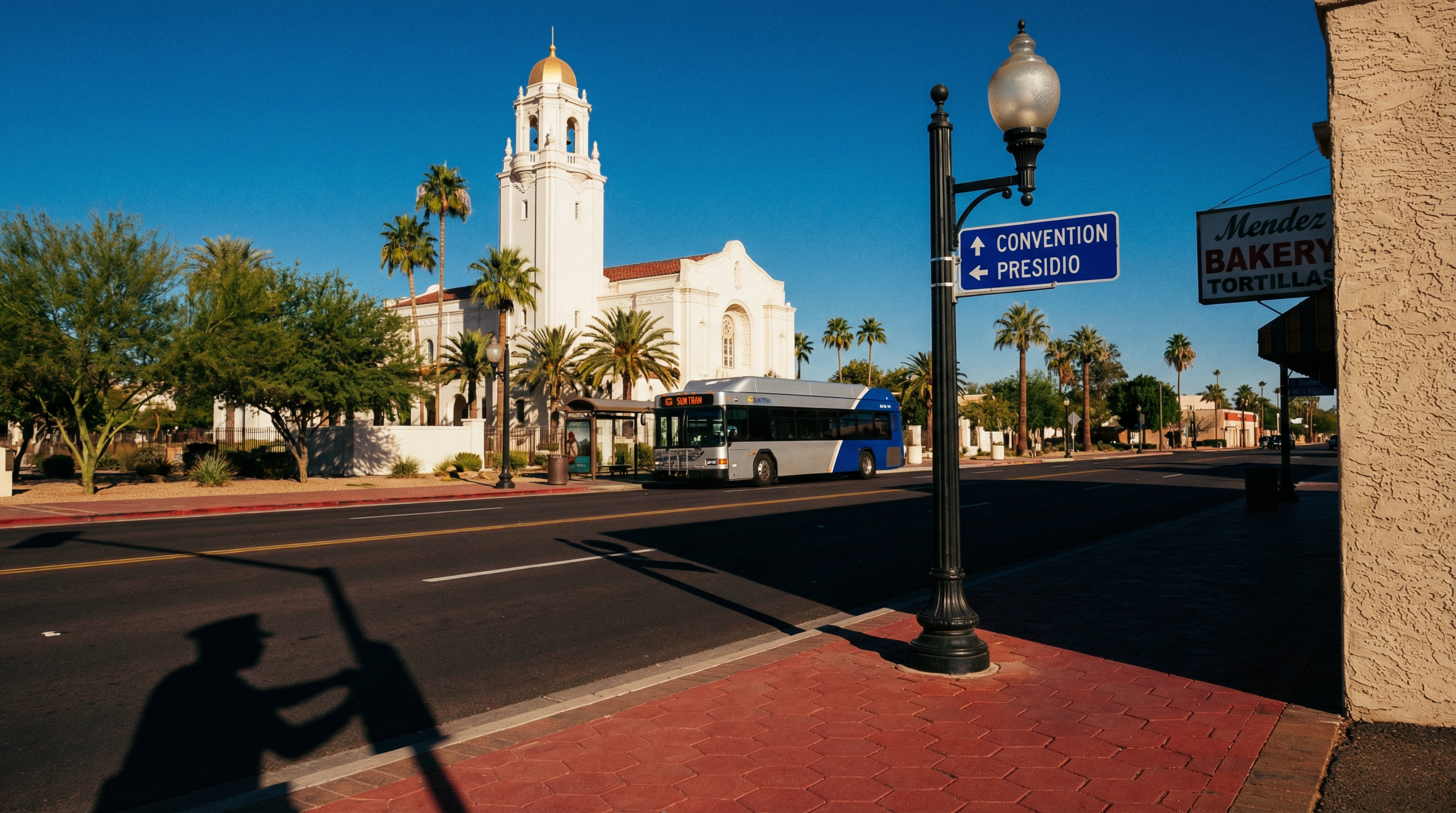 Autobús urbano y paradero junto a avenida soleada